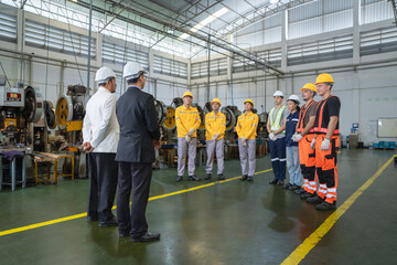 Team of workers and supervisors engaging in safety training session in industrial warehouse environment © Surachai
