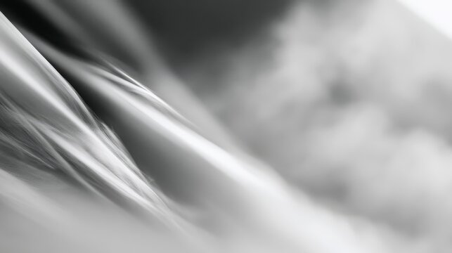 A close-up black and white photo of flowing water, highlighting smooth waves and reflections with a soft, abstract background.