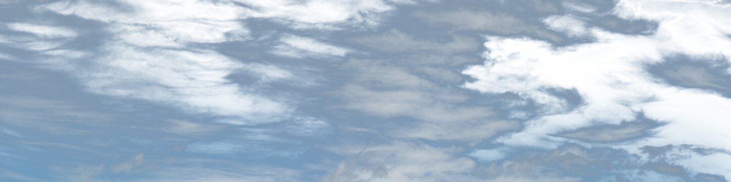 Panorama of a light blue sky with white clouds. Portions of the sky are transparent.
