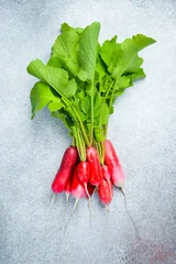 ripe red radishes on a gray concrete background. Close up. © Yaruniv-Studio