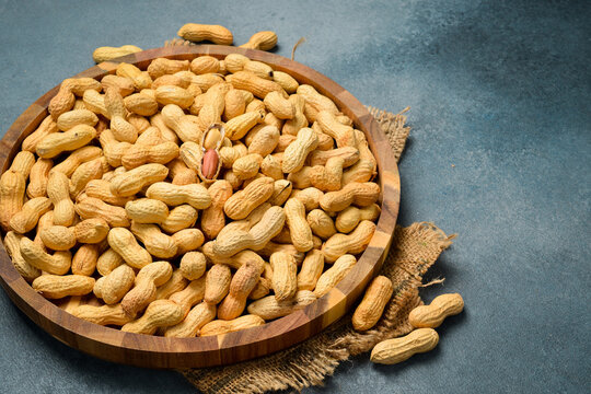 Wooden bowl with peanuts in the shell. Nuts Close-up.