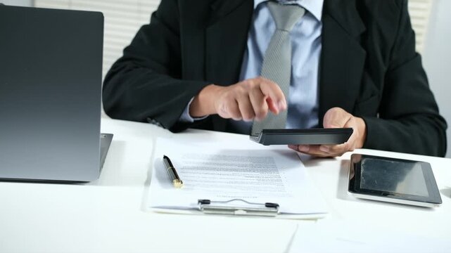 Corporate financial budgeting and accounting professionals calculate financial documents with calculators and laptops in the office to analyze and evaluate company finances.
