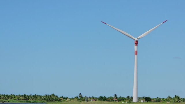 Clean energy solutions: Massive aerogenerators harvesting wind power next to a coastal lagoon.
