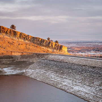 sunrise light over Horsetooth Reservoir, dam and city of Fort Collins - winter scenery with a low water level