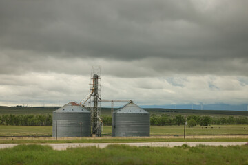 Grain Silos And Elevator On A Rural Farm Under Stormy Overcast Sky In Prairie Landscape © Kenedy