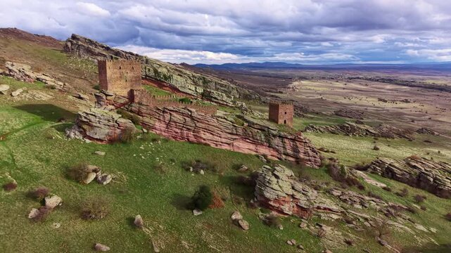 Top view of Castillo de Zafra's twin stone towers and curtain wall along a striated red sandstone ridge, Sierra de Caldereros, Castilla-La Mancha, Spain
