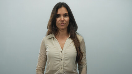 Obraz premium Woman face standing in studio with pale blue backdrop, neutral expression and relaxed posture; quiet confidence.
