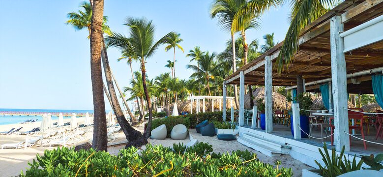 Cafe on Dominicus beach, white sand, sun beds and palms in early morning. Dominican republic 