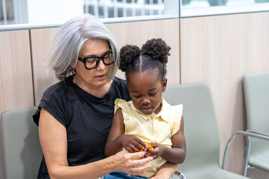 Grandmother comforting grandchild in medical waiting room