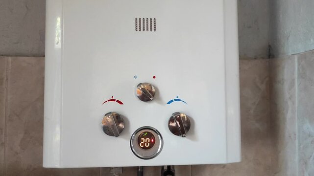 White gas water heater being switched on with temperature control display showing 48 degrees in residential home interior.
