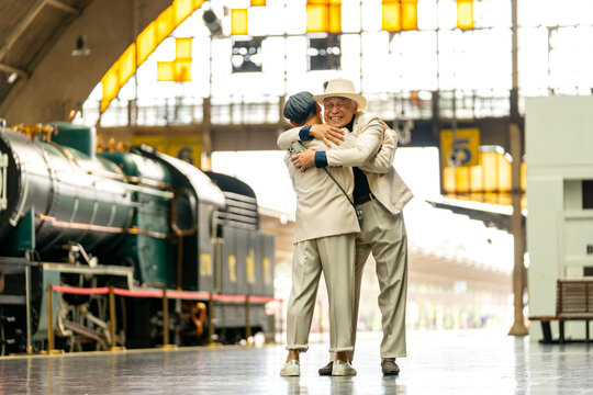Couple Asian senior lovers lgbtq hug together during meet at train station to express care and love after separate for long time.