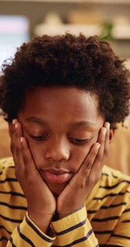 Sad, thinking and child with depression at house, loneliness and bad memory with trauma. Reflection, unhappy kid and African boy with anxiety, boredom or stress with mental health crisis in lounge