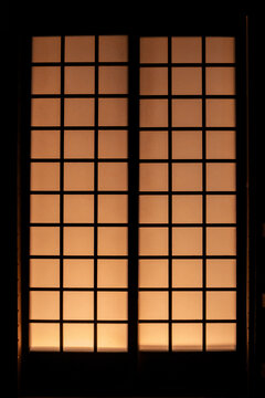 Symmetrical close up of traditional Japanese shoji sliding paper door with warm light