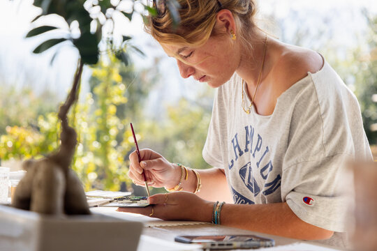 young woman artist working on a watercolor drawing outdoors