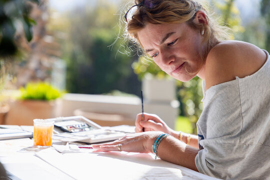 young woman artist working on a watercolor drawing outdoors