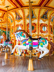 Colorful carousel horse on a vintage merry go round at an amusement park. © kikujungboy