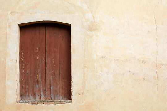 Rustic Closed Wooden Window on an Old Textured Plaster Wall in the Medieval Village of Mura, Spain