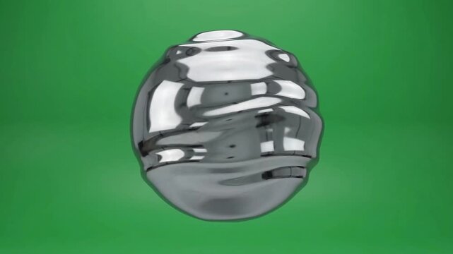Shiny metallic sphere floats against green screen