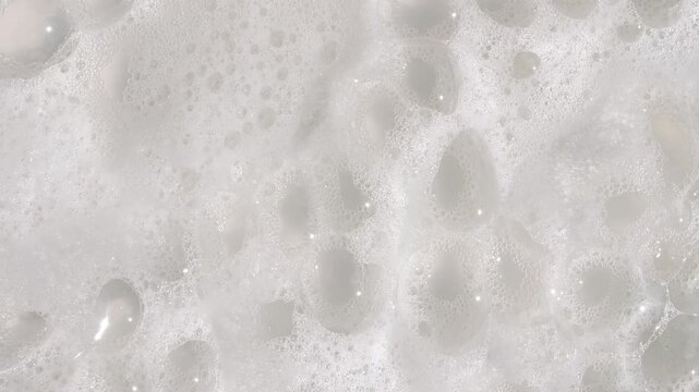Texture of white soap foam with bubbles abstract background. Soap sud macro structure. Bathtup Soap Foam. Natural White Shampoo Bubbles Motion. High quality 4k footage