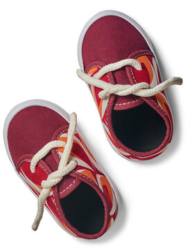 pair of red patterned canvas baby shoes isolated white background, white laces and rubber soles infant footwear, close-up top view