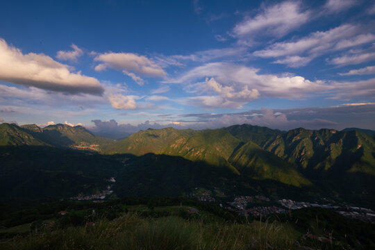 Alpine valley landscape with village and dramatic cloud formations, Lombardy, Italy, Val Trompia.
