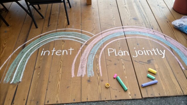 Colorful Chalk Art on Wooden Floor Illustrating Intent and Joint Planning for Collaborative Activities