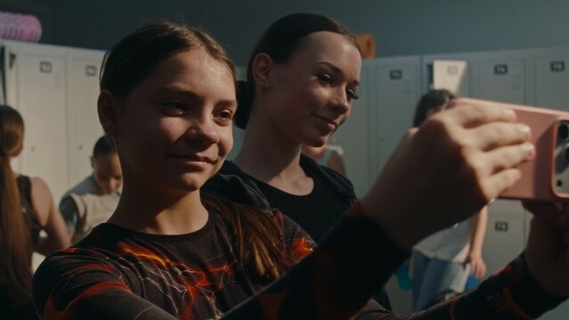 Two Gymnasts Taking Selfie in Locker Room Before Practice. Smiling Teammates Capture Fun Moment Together While Preparing for Training. Friendship, Team Spirit, Youth Sports, Modern Digital Lifestyle.