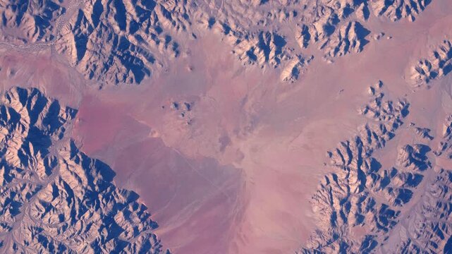 Rotating aerial view of red desert sand and rugged mountains from space based on Nasa imagery