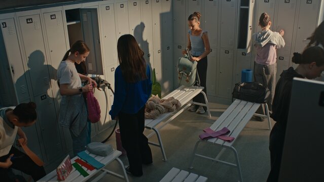 Group of Rhythmic Gymnasts Getting Ready in Busy Locker Room Before Practice. Girls Organize Sports Bags, Change Clothes and Prepare Equipment. Concept of Youth Sports, Teamwork, Athletic Preparation.