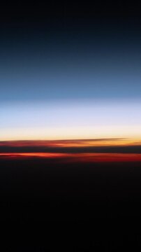 Vertical orbital sunrise over Earth's curved horizon atmospheric glow from space based on Nasa imagery