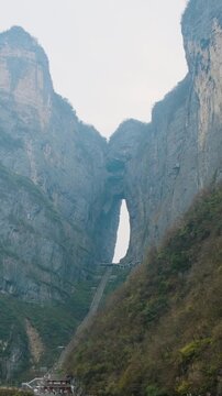 Heaven gate stone arch with steep staircase between towering cliffs at sunrise.in Tianmen Mountain National Park, Zhangjiajie, Hunan, China. Tianmen cave with 999 steps. Travel and tourism landmark