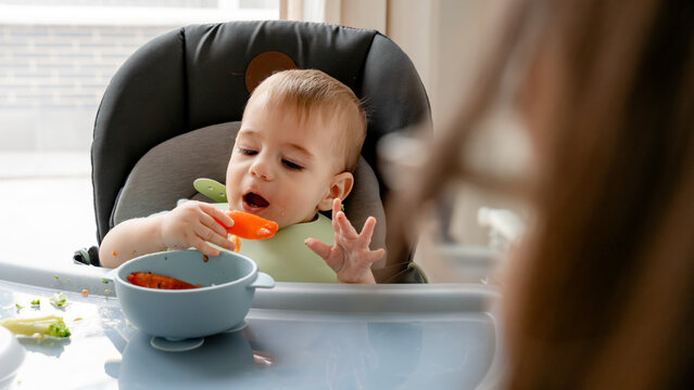 Baby explores solid foods through baby-led weaning