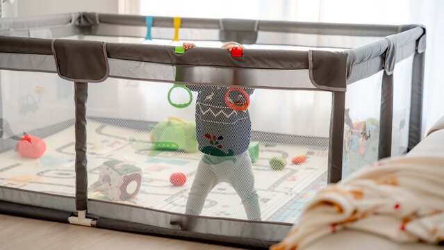 Baby playing safely in playpen at home