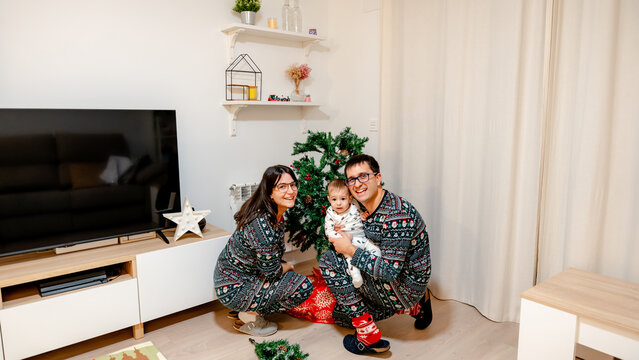 Family decorating a Christmas tree in cozy living room