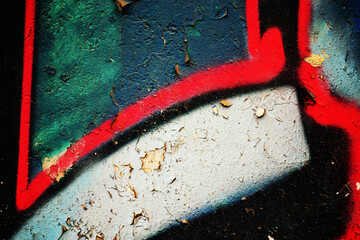 Close-up of colorful urban graffiti fragments on a weathered abandoned wall featuring vibrant spray paint, distressed concrete, grunge texture and street art details. Perfect abstract urban background © djjeep_design