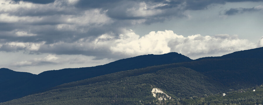 Dramatic Landscape View of Mountain Ridges Under a Cloudy Sky at Golden Hour