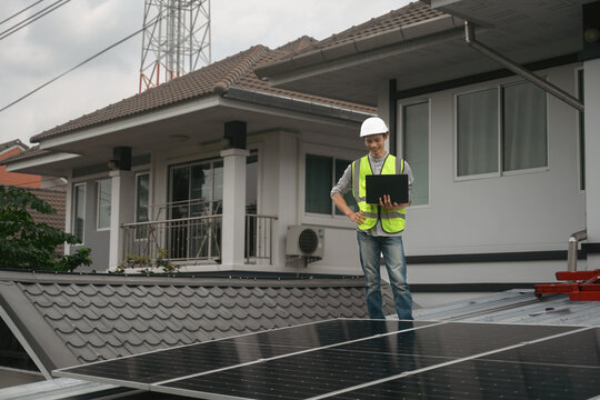 Solar Panel Engineer Inspecting Home Rooftop Installation with Laptop