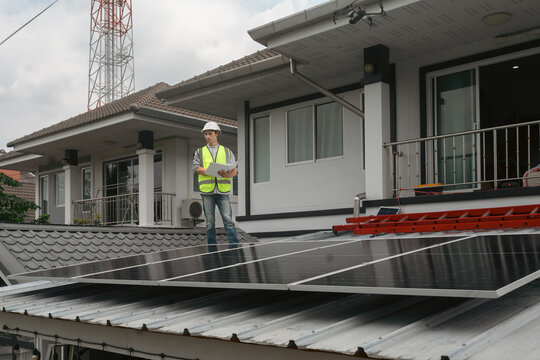 Solar Panel Installation Engineer Inspecting Rooftop Photovoltaic System at Residential Home