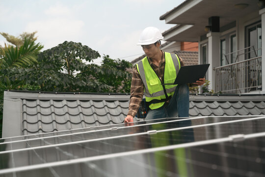 Solar Panel Technician Installing and Inspecting Photovoltaic System on Residential Home Rooftop