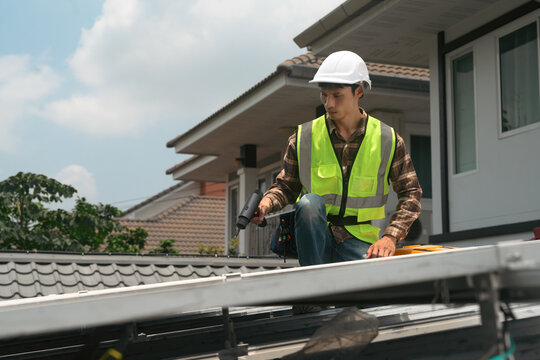 Solar Panel Installation Technician Working on Residential Rooftop with Power Drill