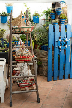 Nautical patio decor with model boats and blue fence, Palamos