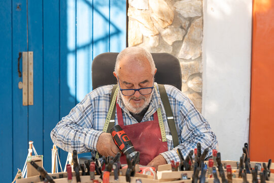Craftsman using cordless drill in Palamos workshop scene