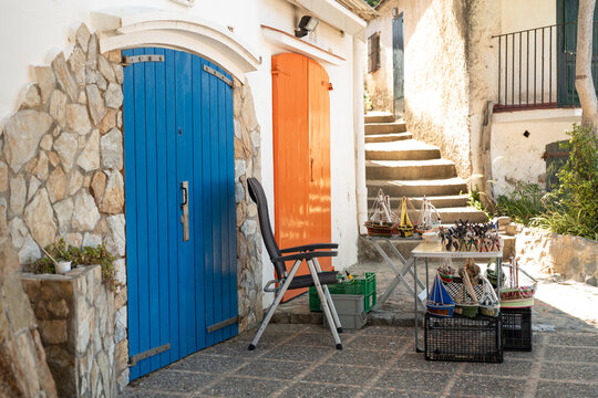 Colorful doors and model boats in a Palamos alleyway