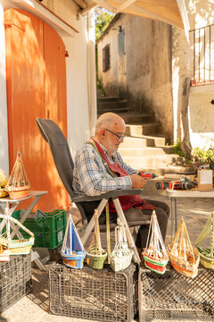 Artisan crafting model fishing boats at Palamos market stall