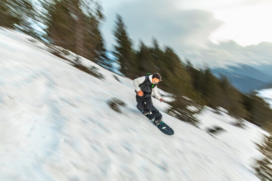 Snowboarder racing down a snowy mountain slope