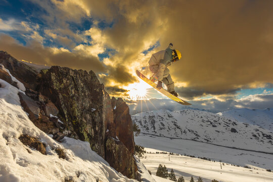 Snowboarder jumping with sunset in Pyrenees