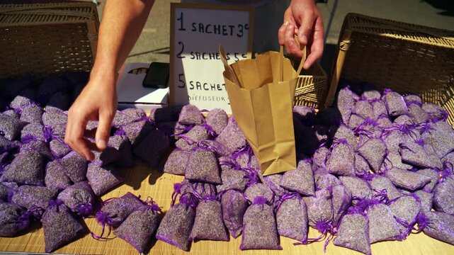 Hands preparing bags of dried lavender sachets for sale at a local market, promoting natural fragrance and aromatherapy