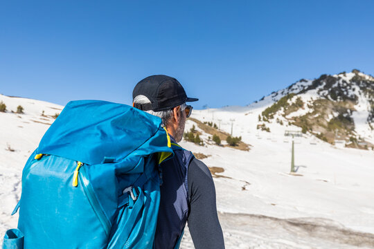 Man hiking with backpack in snowy Pyrenees landscape