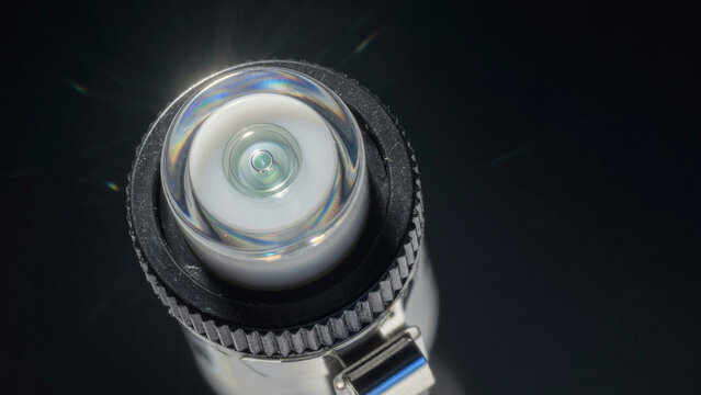 Close-up view of a flashlight on a dark background with light shining