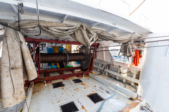 Fishing boat deck with industrial winch and coiled cable